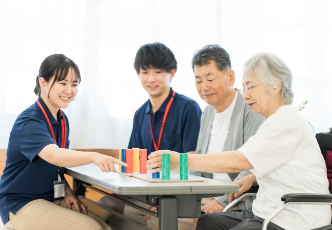 リハビリを行うシニア女性とスタッフ